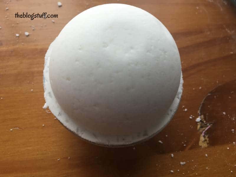 A white bath bomb on a wooden surface