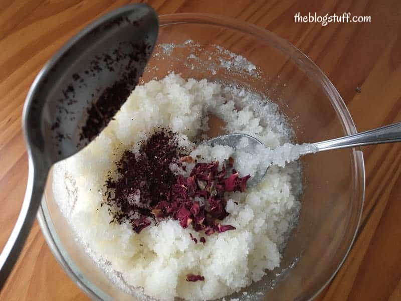 Adding rose and hibiscus flowers to the scrub mixture