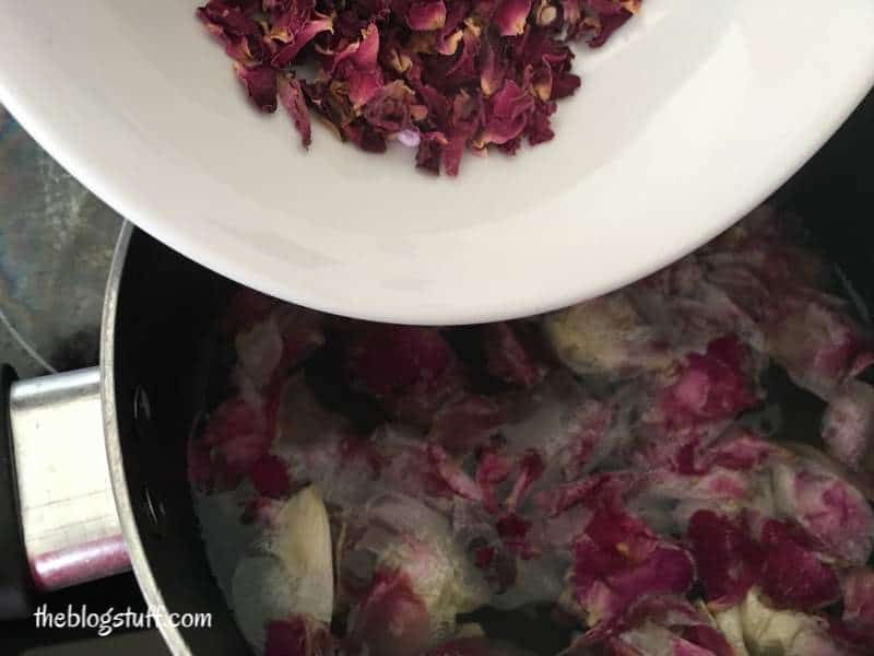 Adding dry rose petals to the simmering rose water