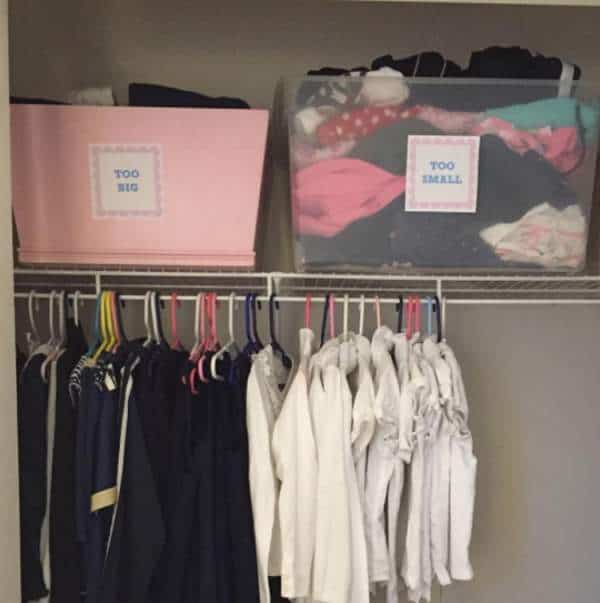 Baby clothes in hangers and storage baskets in the closet