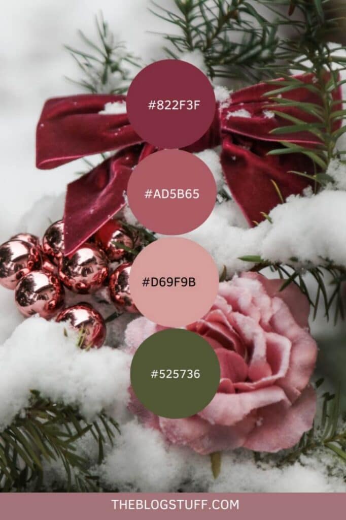 Burgundy ribbon, pink rose, and pink baubles in snow-covered evergreens for a cozy, elegant Christmas decor.