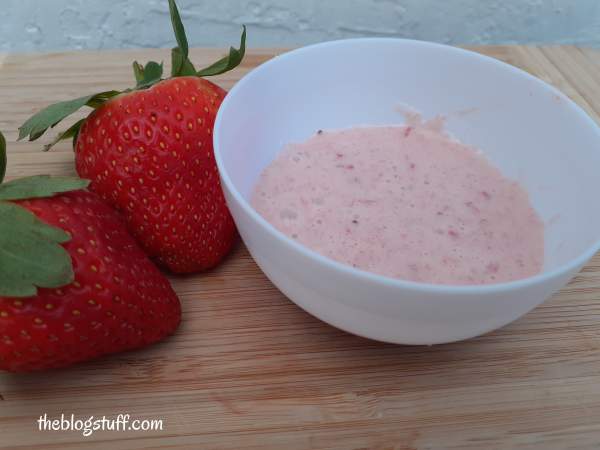 Homemade skin tightening remedy on a bowl and 2 strawberries by The Blog Stuff