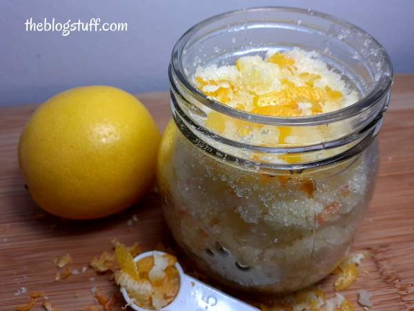 A lemon and DIY lemon sugar scrub in a glass jar