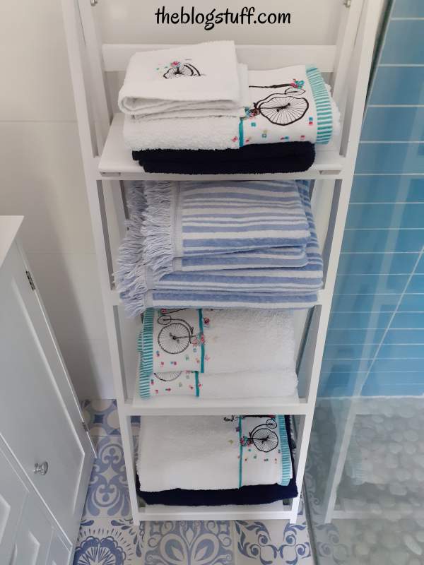 Bathroom towels folded on a decorative ladder