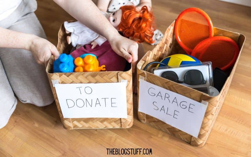 Two labeled baskets, 'To Donate' and 'Garage Sale,' filled with toys and items for decluttering and cleaning before Christmas.