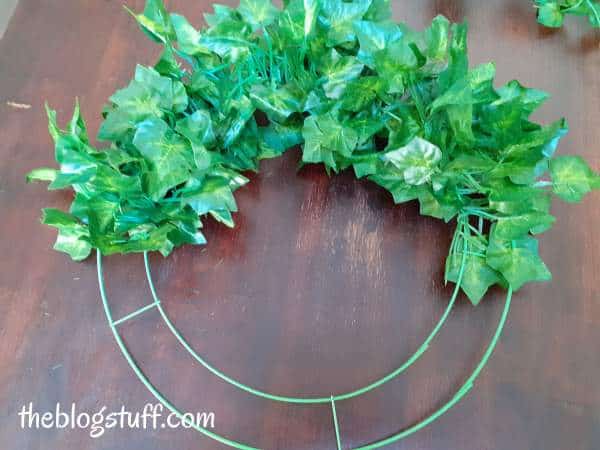 Greenery around a metal hoop with green wire