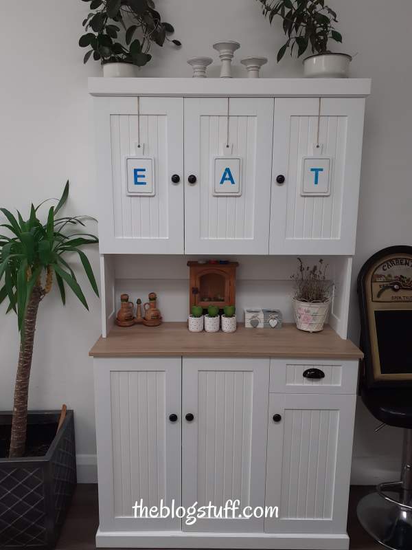 3 wooden cutting boards hanging from a kitchen cabinet