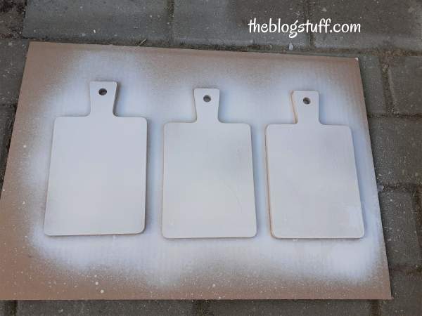 Spraying paint on 3 wooden cutting boards