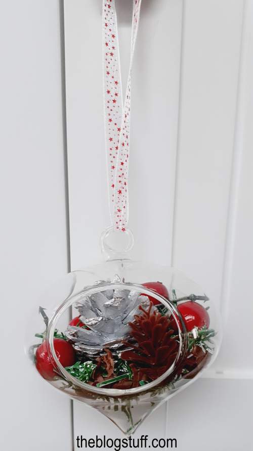 DIY Christmas bauble with miniature pinecones and berries