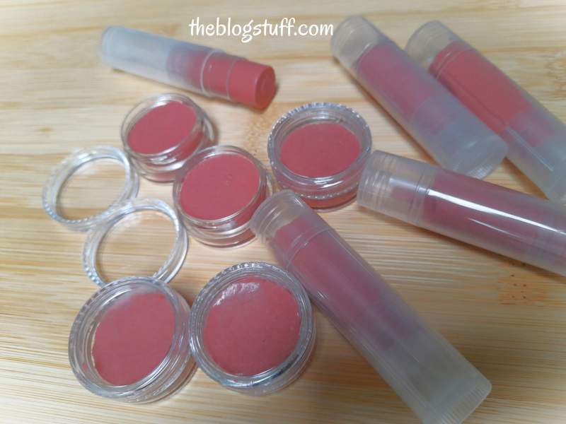 Lip balm in containers over wood