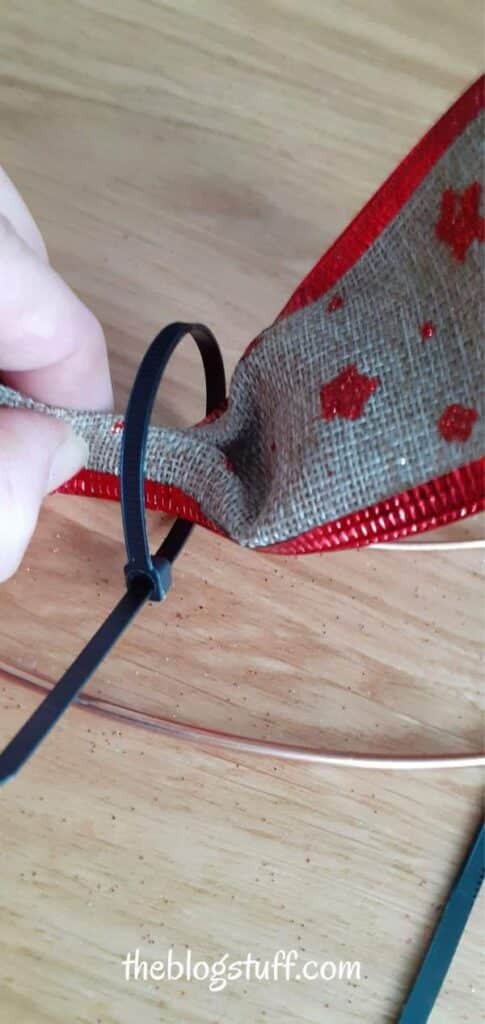 Attaching a ribbon to wreath wireframe with a zip tie