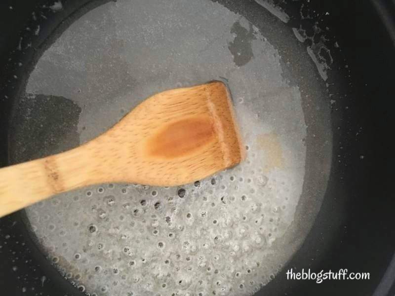 Stirring DIY sugar wax with a wooden spoon