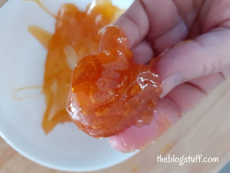 Hand holding homemade sugar wax 