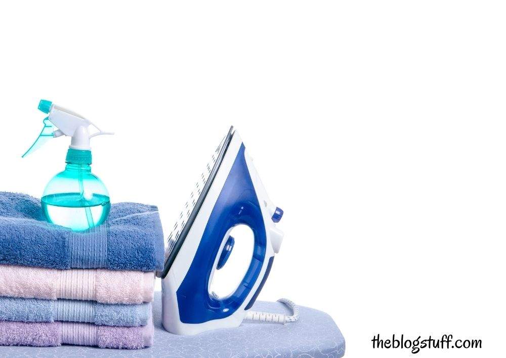 Iron and towels with a spray bottle on top