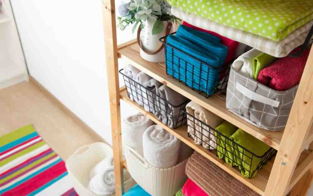 Wooden shelves with baskets storing linens