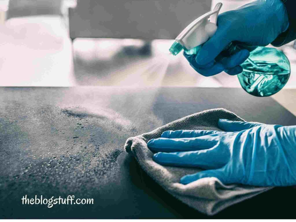 Cleaning a kitchen surface with a spray bottle and a cloth