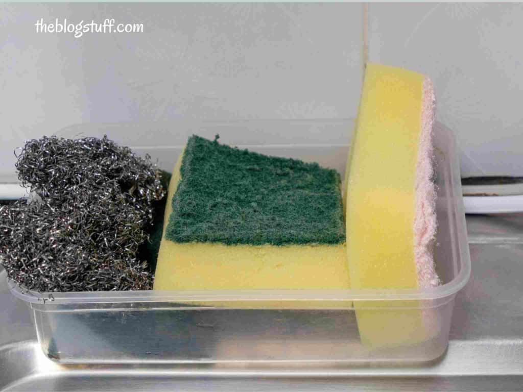 A plastic container holding 3 kitchen sink sponges