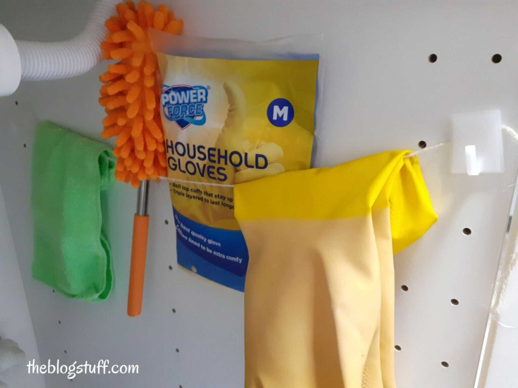 Organizing under kitchen sink cleaning supplies with a tension rod