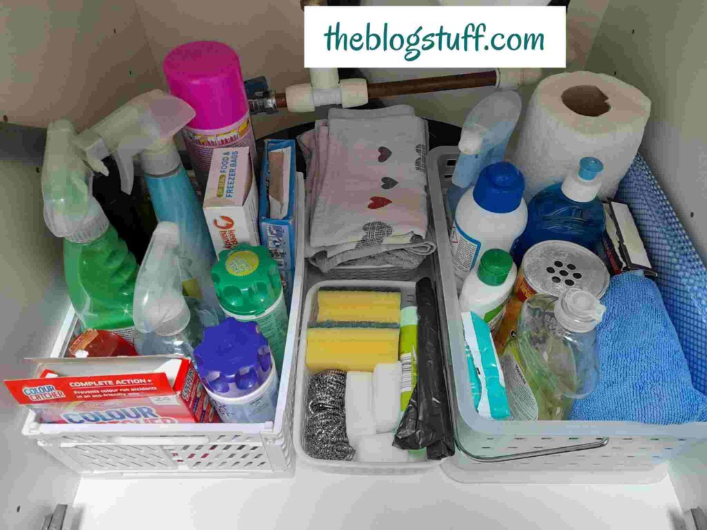 4 baskets with cleaning supplies under the kitchen sink