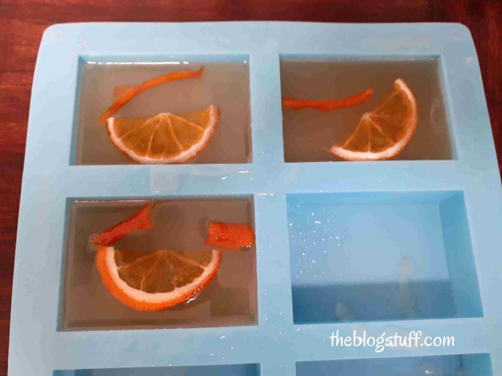 Orange slices and peels in a blue silicon soap container