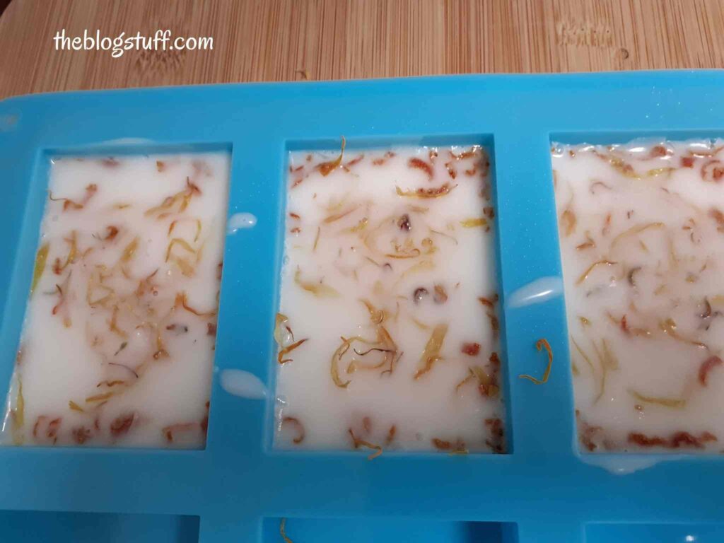 Blue silicon mold with soap and calendula flowers on top