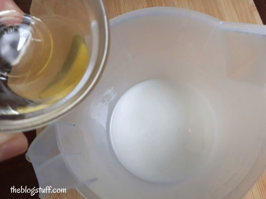 Melted soap base in container and pouring almond oil