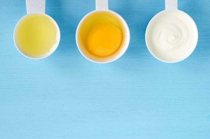 3 spoons with olive oil, egg, and yogurt