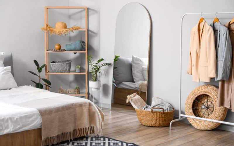 Mirror, bed, clothes and decorative elements in bedroom