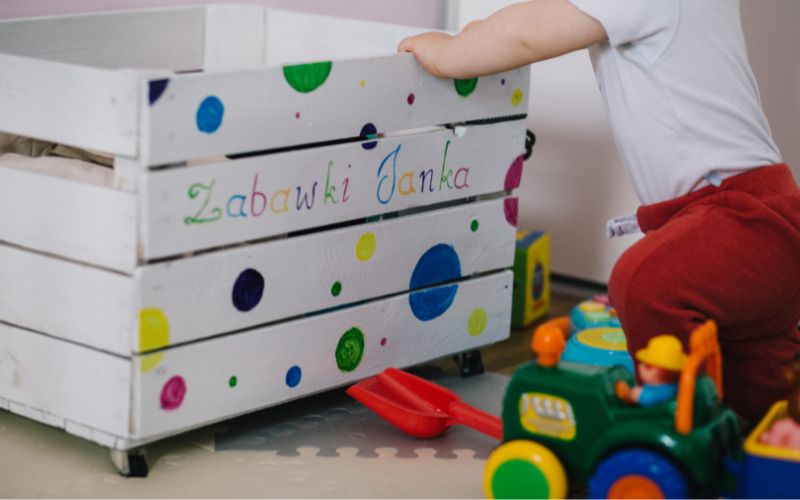 Child keeping toys in a wooden organizer