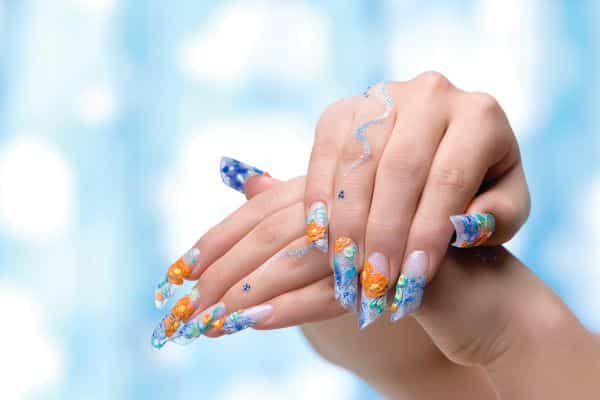 Stiletto nails with an orange and blue floral design