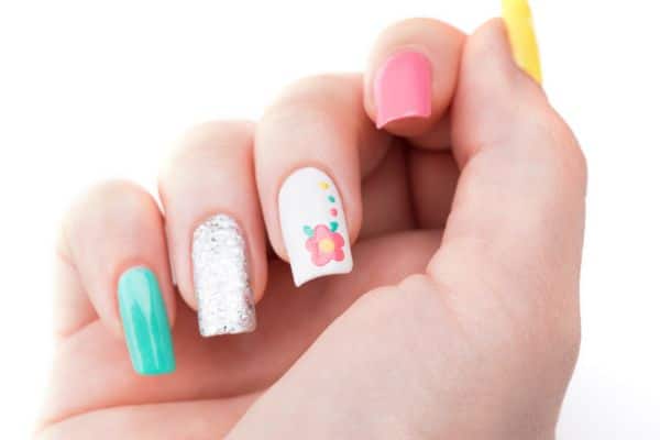 Green, pink white and silver glitter nails with a spring flower desing on one of the nails