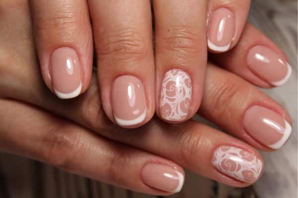 French manicure short nails with a soft pink color, flowers, and white tips