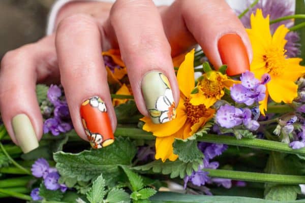 Gren and orange square nails with spring flowers in two of them