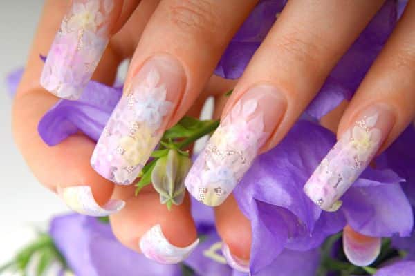 Pastel long nails with lace like patterns and soft colored flowers