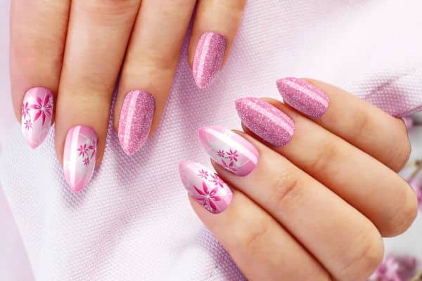 Shimmer pink almond shape nails with pink flowers and pink glitter