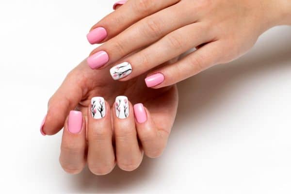 Bubblegum pink square nails with a floral spring pattern in some nails