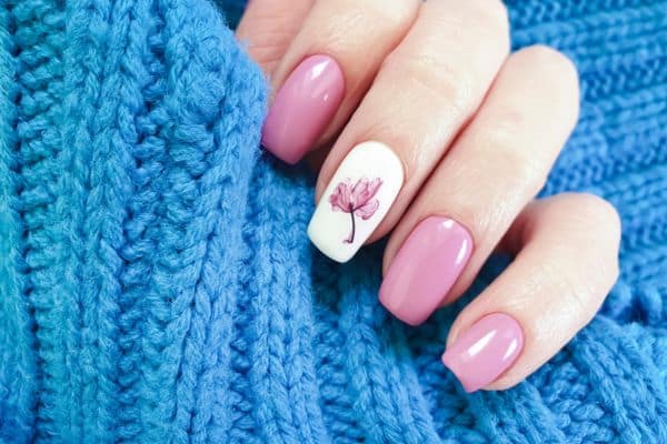 Soft pink nails with a rose design in one finger