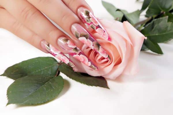 Stiletto nails with a floral design of pink rose petals