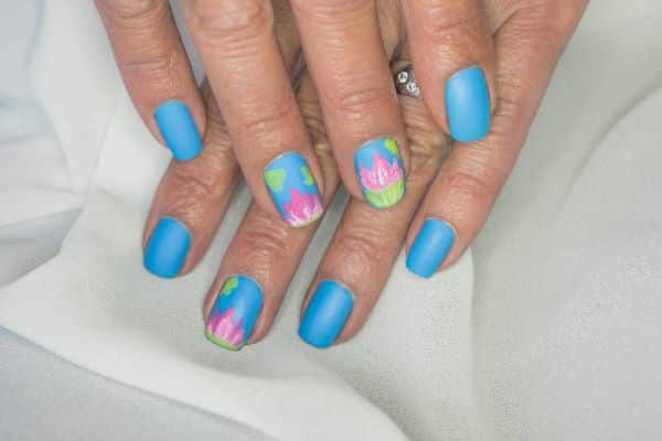 Blue nails with flower designs in pink, green and yellow