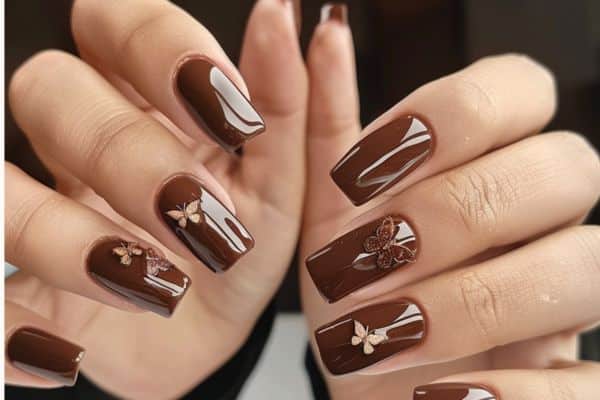 Long glossy brown nails with 3d butterflies in some of the nails