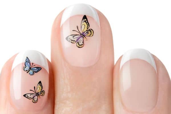 Clear short nails with colorful butterflies in two of the nails