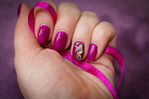 Dark pink nails with a golden butterfly design in one nail