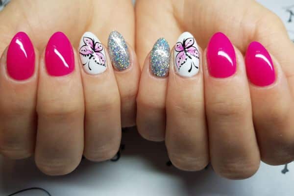 Hot pink nails with a butterfly design on a white background in two nails and other two nails with silver glitter