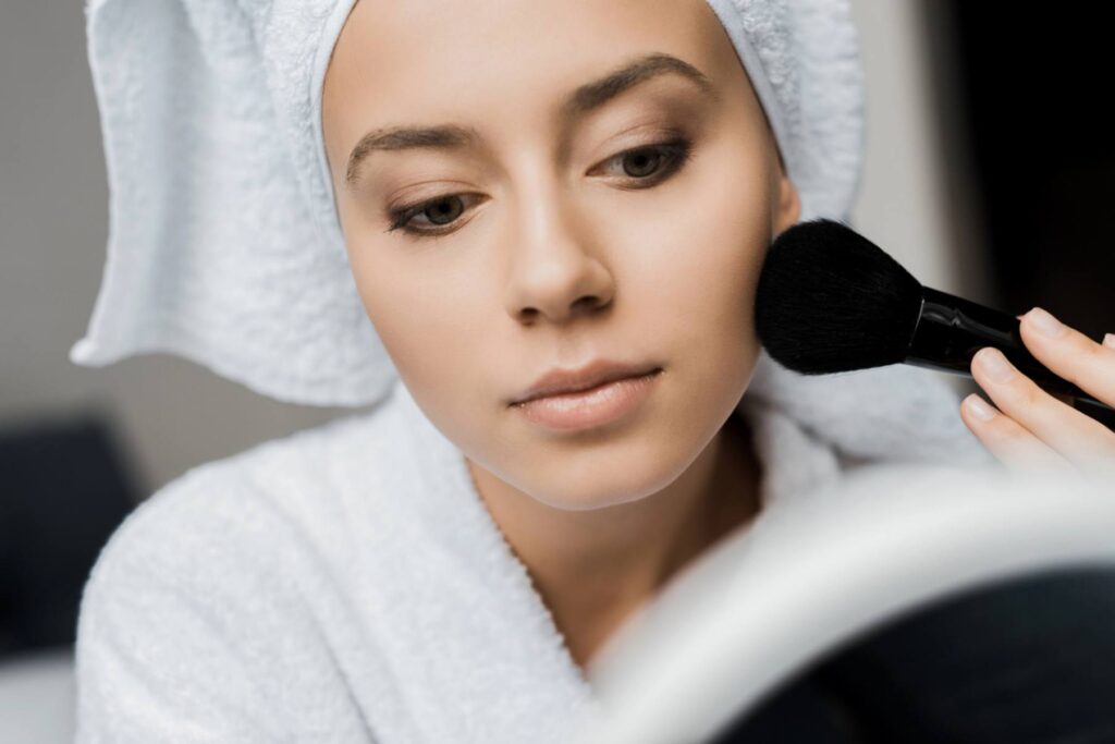 A woman applying setting powder to her face