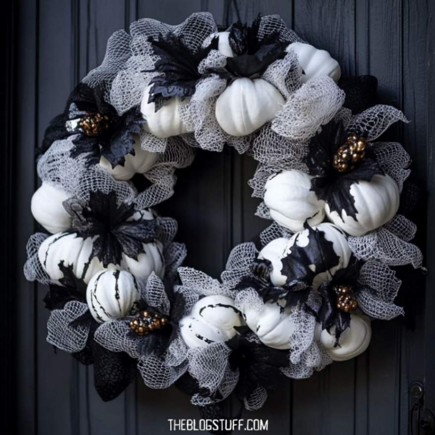 Black and white Halloween wreath with white pumpkins, black leaves, and mesh details on a dark door.