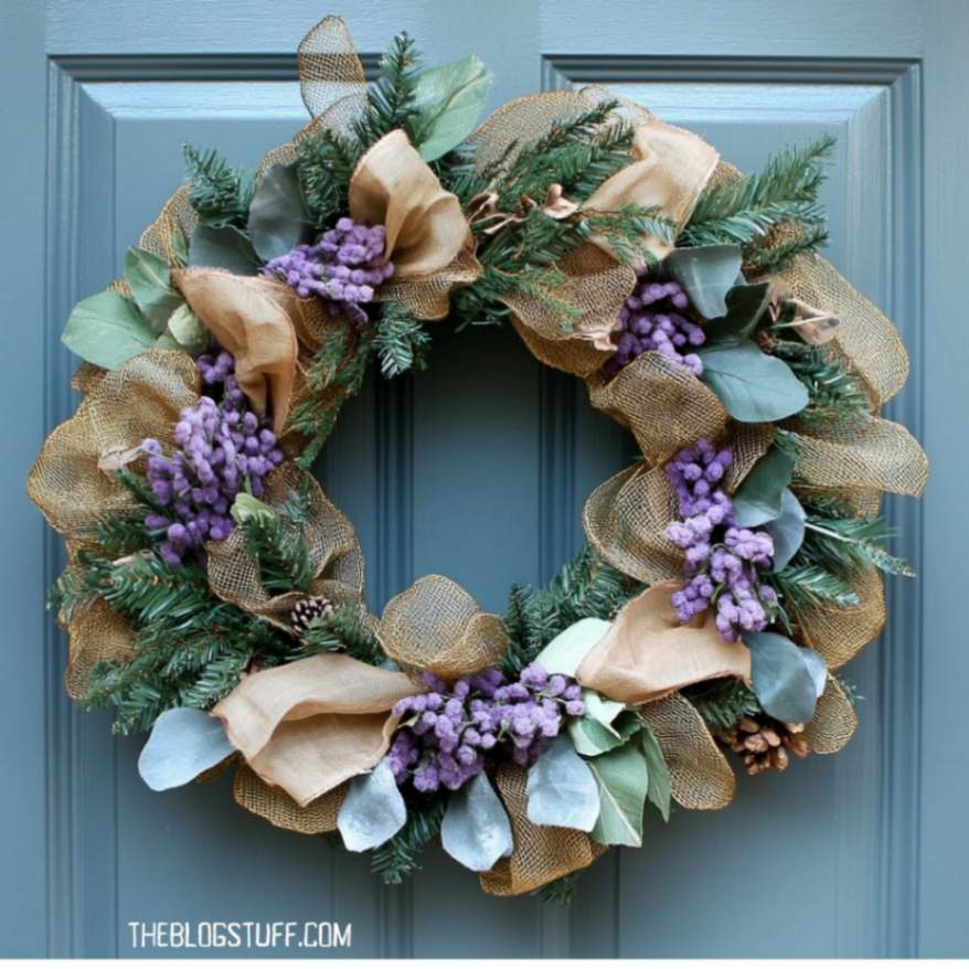 Burlap Halloween wreath with greenery and purple berries.