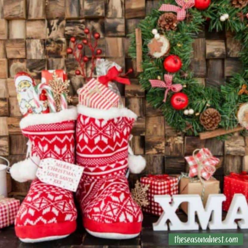 Holiday boots filled with gifts and paired with a festive wreath and presents.