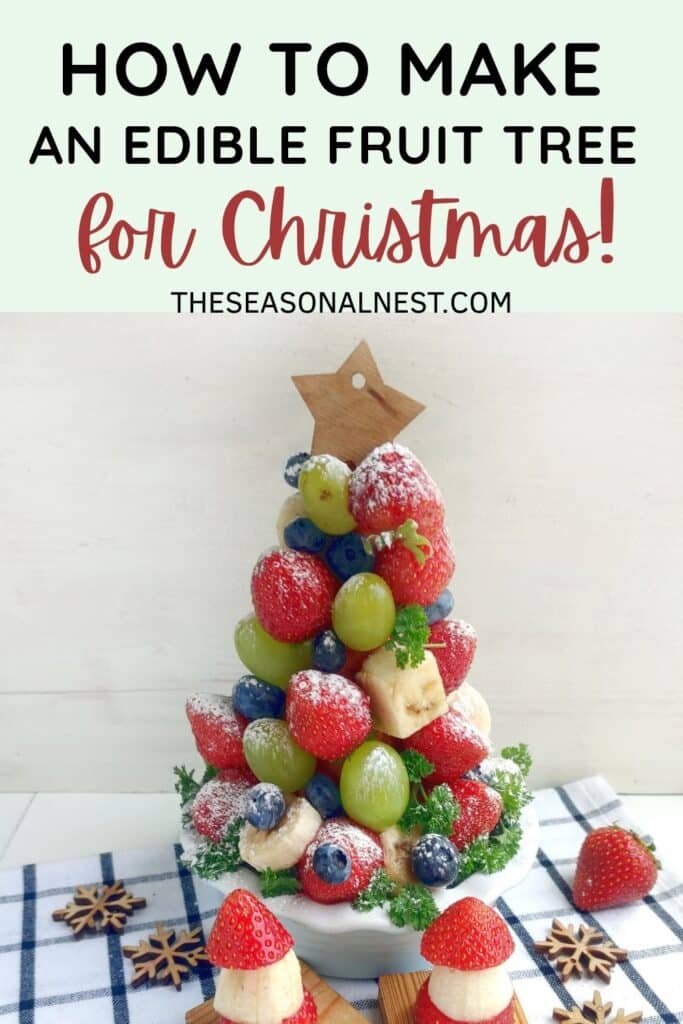 Festive and colorful fruit Christmas tree decoration made with strawberries, grapes, blueberries, and banana.