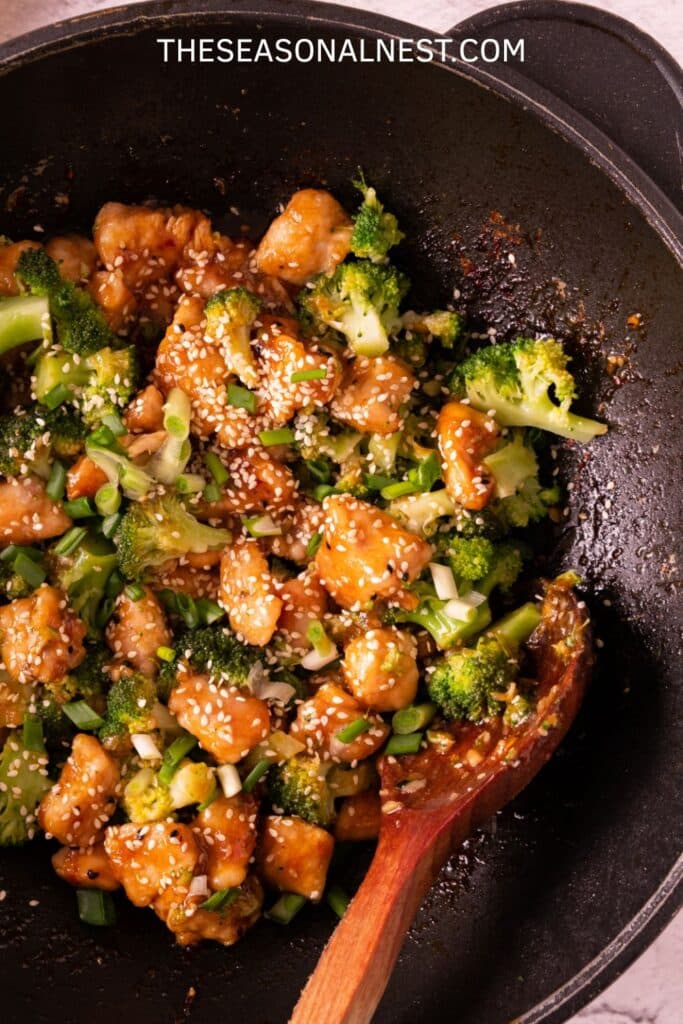 Easy honey garlic chicken and broccoli served on a plate with sesame seeds and scallions.