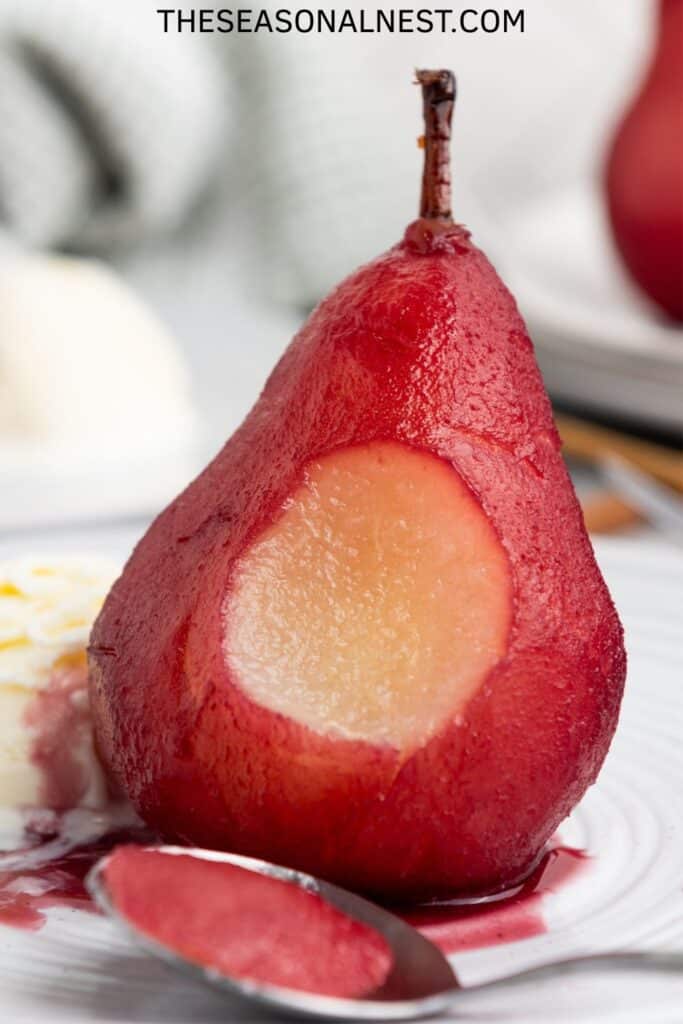 Close up off a pear made in wine with a spoon